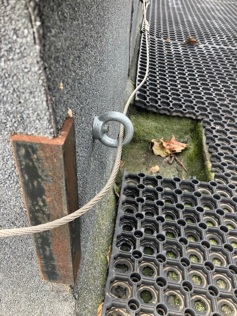 loose lifeline cable threaded through an eyebolt on unsafe structure