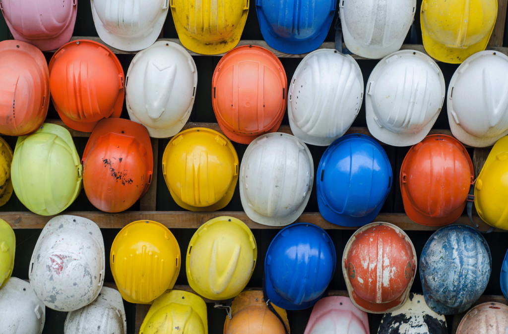 colour hard hats on a wooden frame