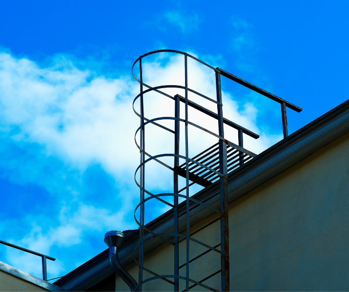 Access ladder on the site of an industrial building going up onto the roof
