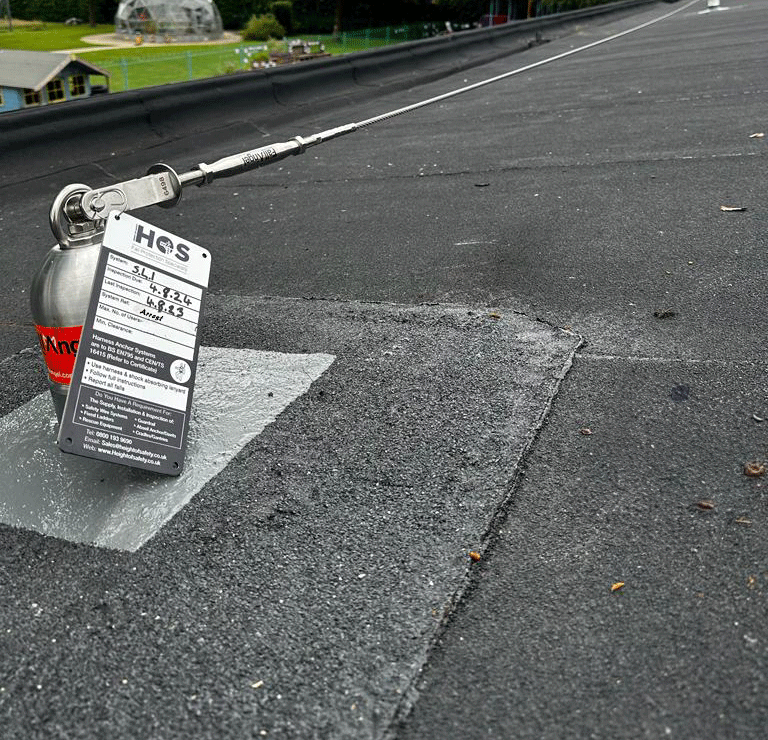 Fall arrest post and cable system on a flat roof
