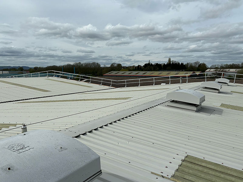 Top fix guardrail on an industrial roof installed to follow the roof's slope and layout.