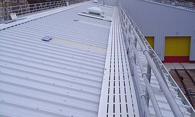 Anti-slip walkway with edge protection on an industrial roof.