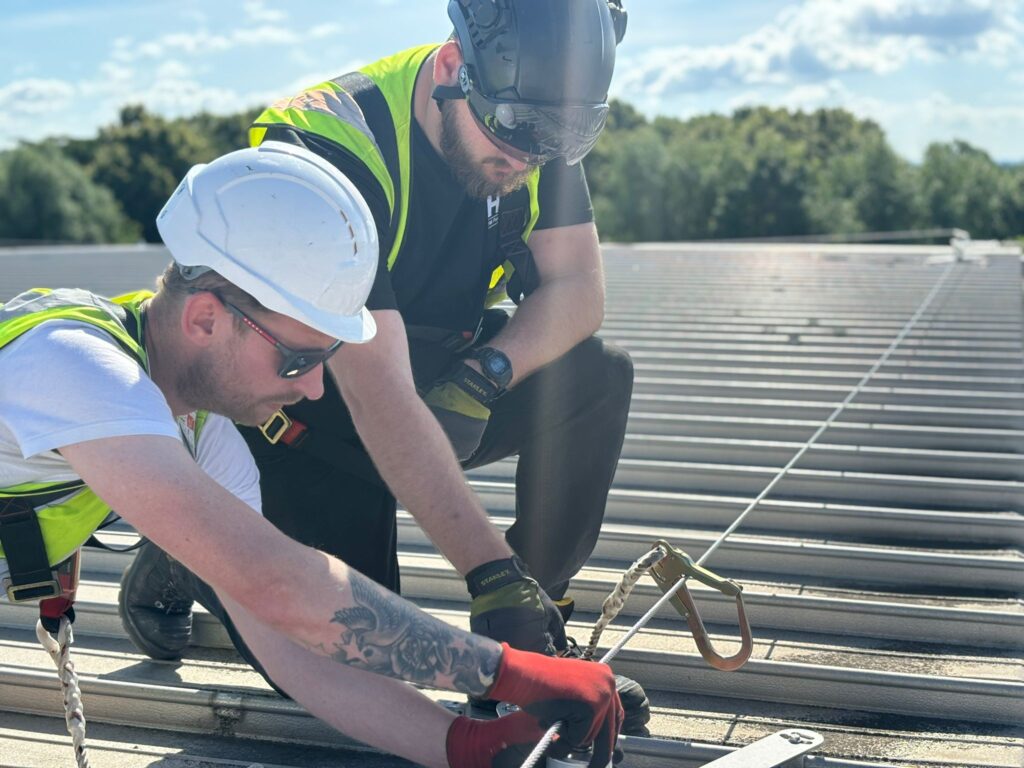 Two workers inspecting a fall protection lifeline system